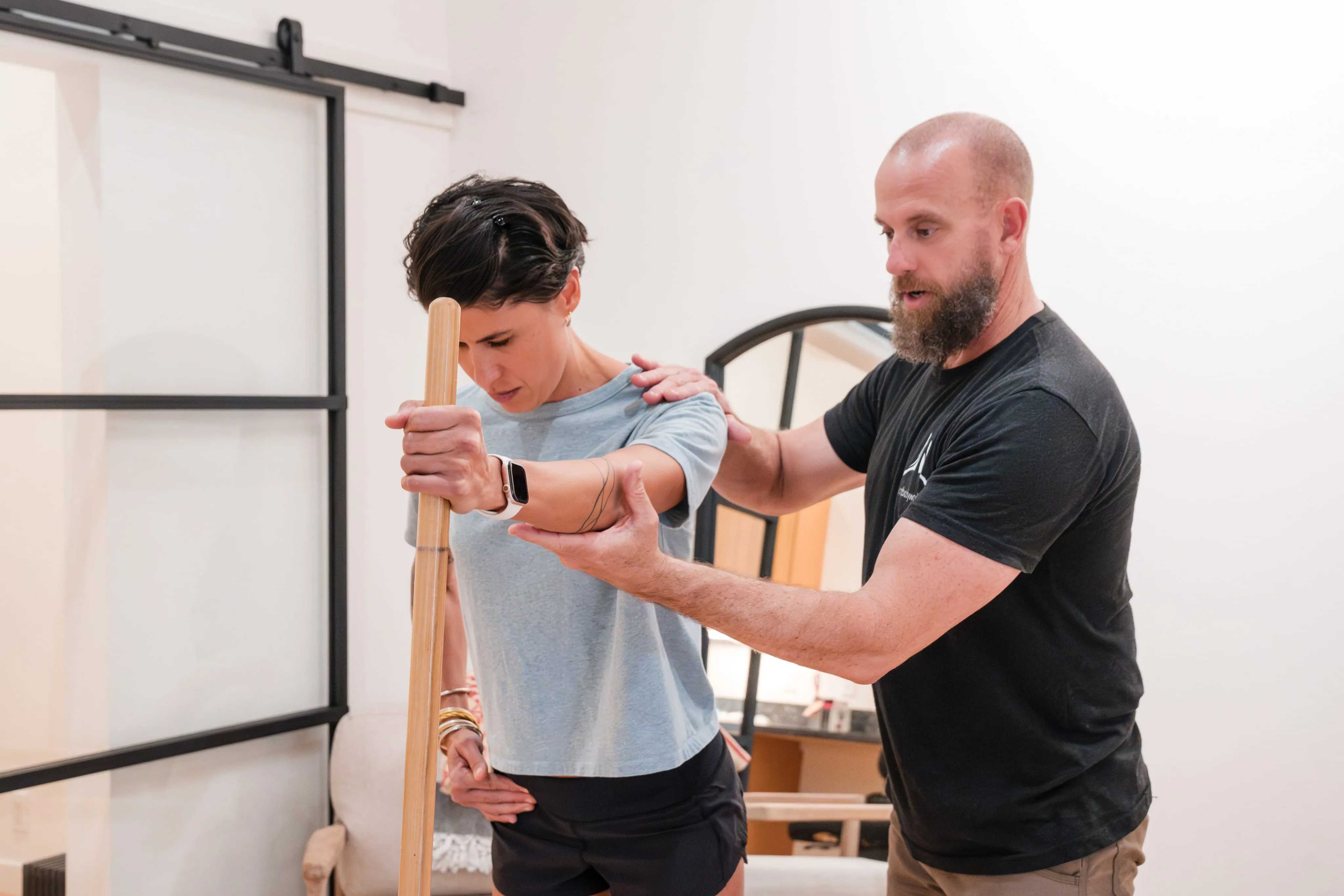 A therapist guiding a client through a movement assessment