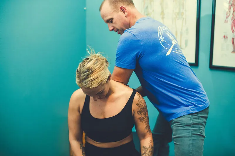 A therapist assessing a client's movement during treatment